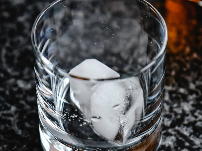 Shot glass with ice cubes to pour the mixed cocktail ingredients